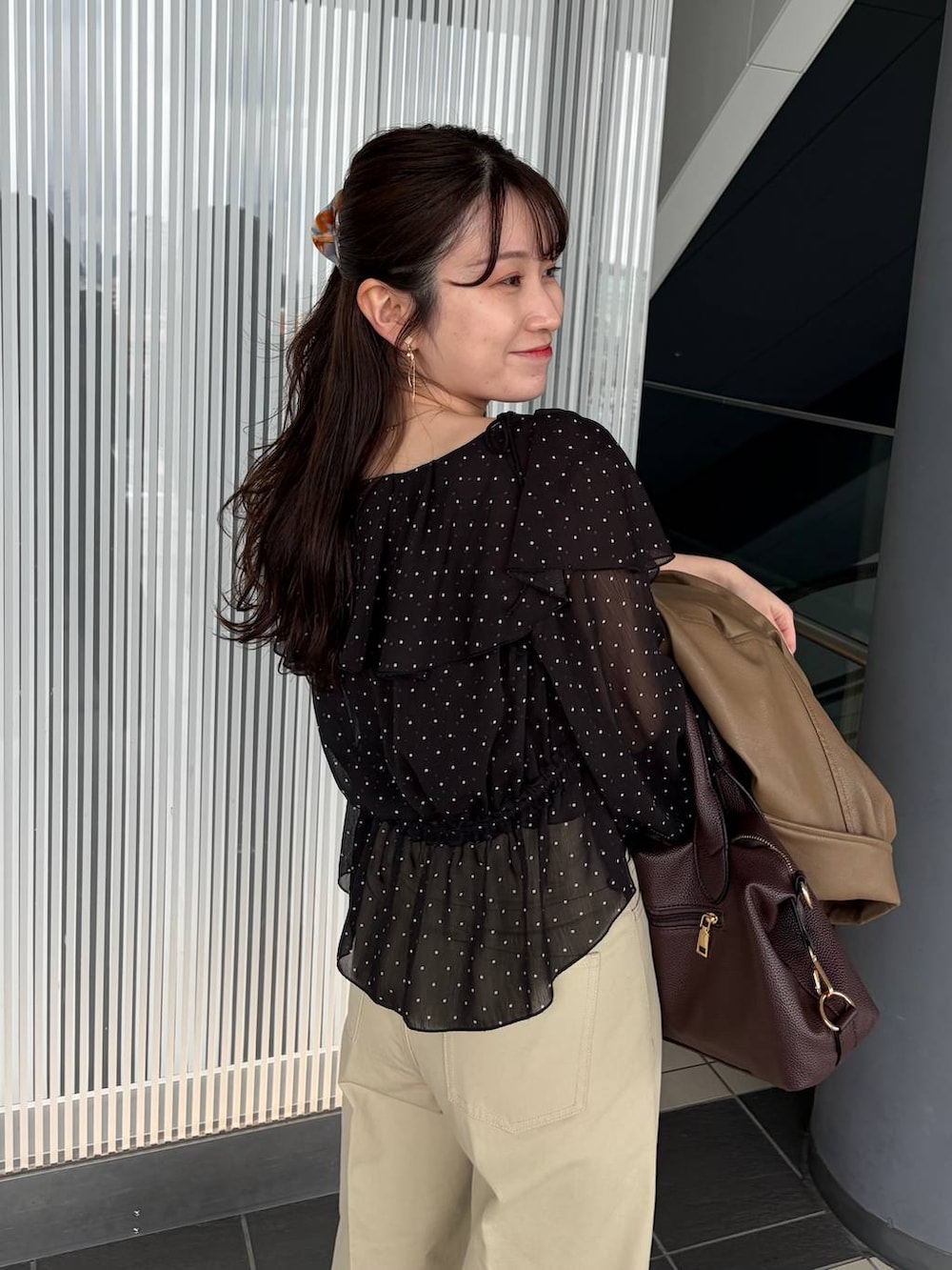 ブラウン系のボストンバッグ、ブラウン系のブルゾン、ブラック系のシャツ/ブラウスを着用したレディースの春コーディネートの6枚目の写真