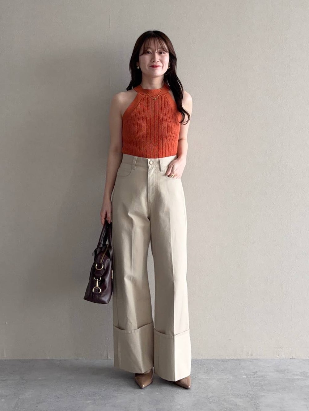 ホワイト系のパーカー、ブラウン系のボストンバッグ、ブラウン系のサンダルを着用したレディースの春コーディネートの4枚目の写真