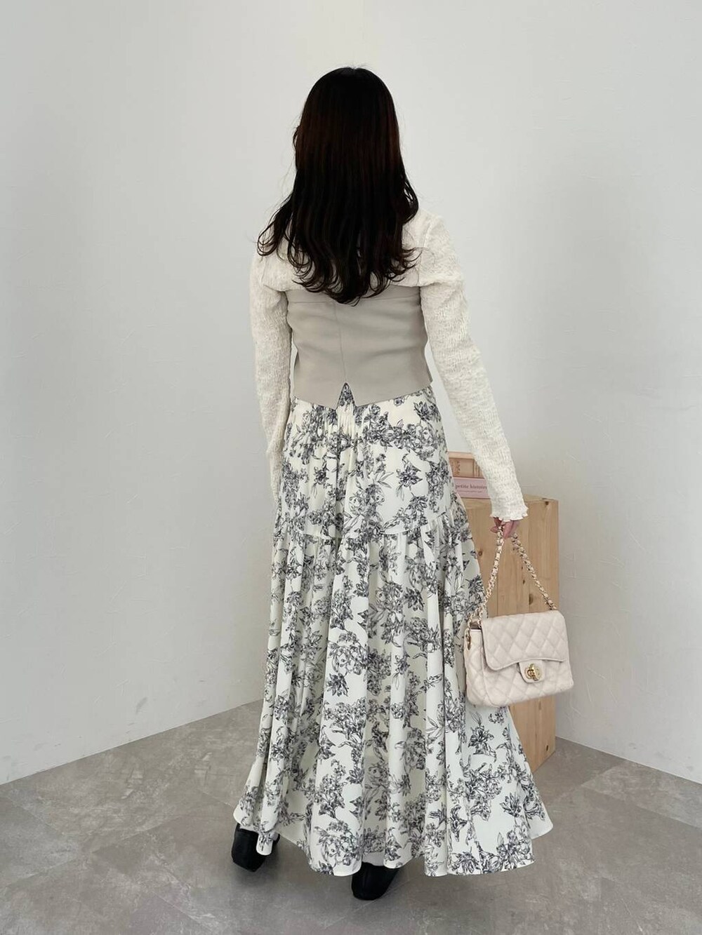 ホワイト系のショルダーバッグ、ホワイト系のスカート、ホワイト系のTシャツ/カットソーを着用したレディースの冬コーディネートの2枚目の写真