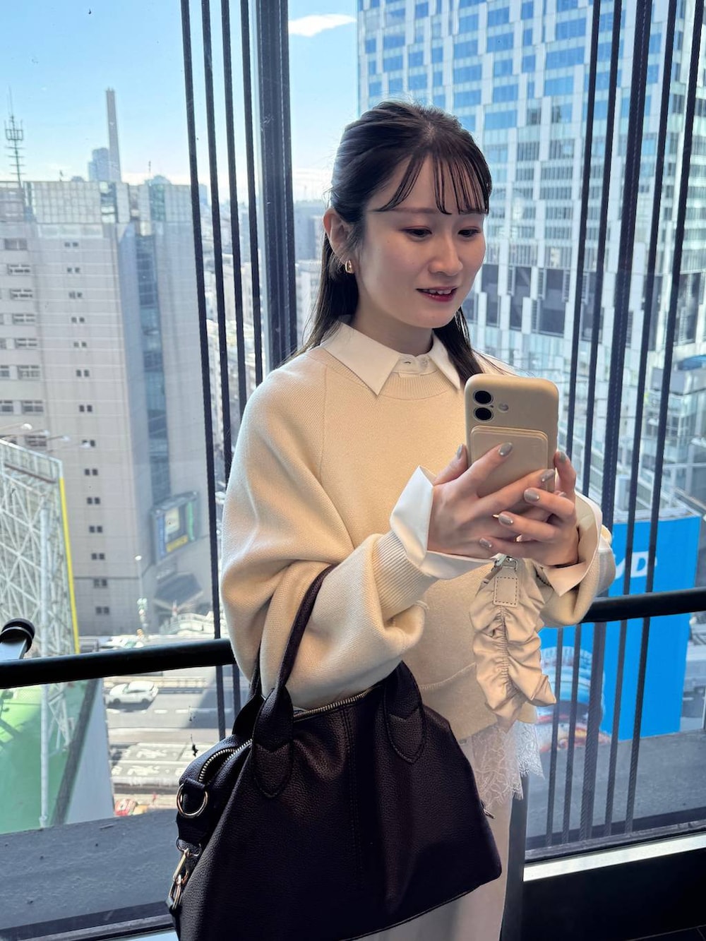 ブラウン系のボストンバッグ、ホワイト系のスラックス、ホワイト系のニット/セーターを着用したレディースの冬コーディネートの3枚目の写真