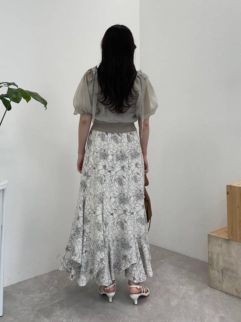 ブラウン系のショルダーバッグ、ホワイト系のスカート、ホワイト系のサンダルを着用したレディースの夏コーディネートの2枚目の写真