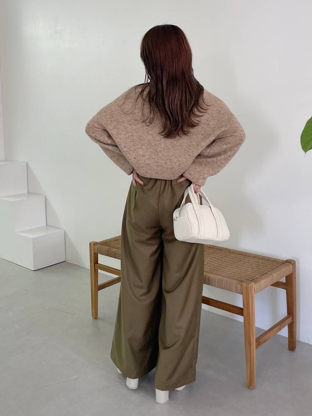 ホワイト系のボストンバッグ、ホワイト系のブーツ、ベージュ系のカーディガン/ボレロを着用したレディースの秋コーディネートの2枚目の写真