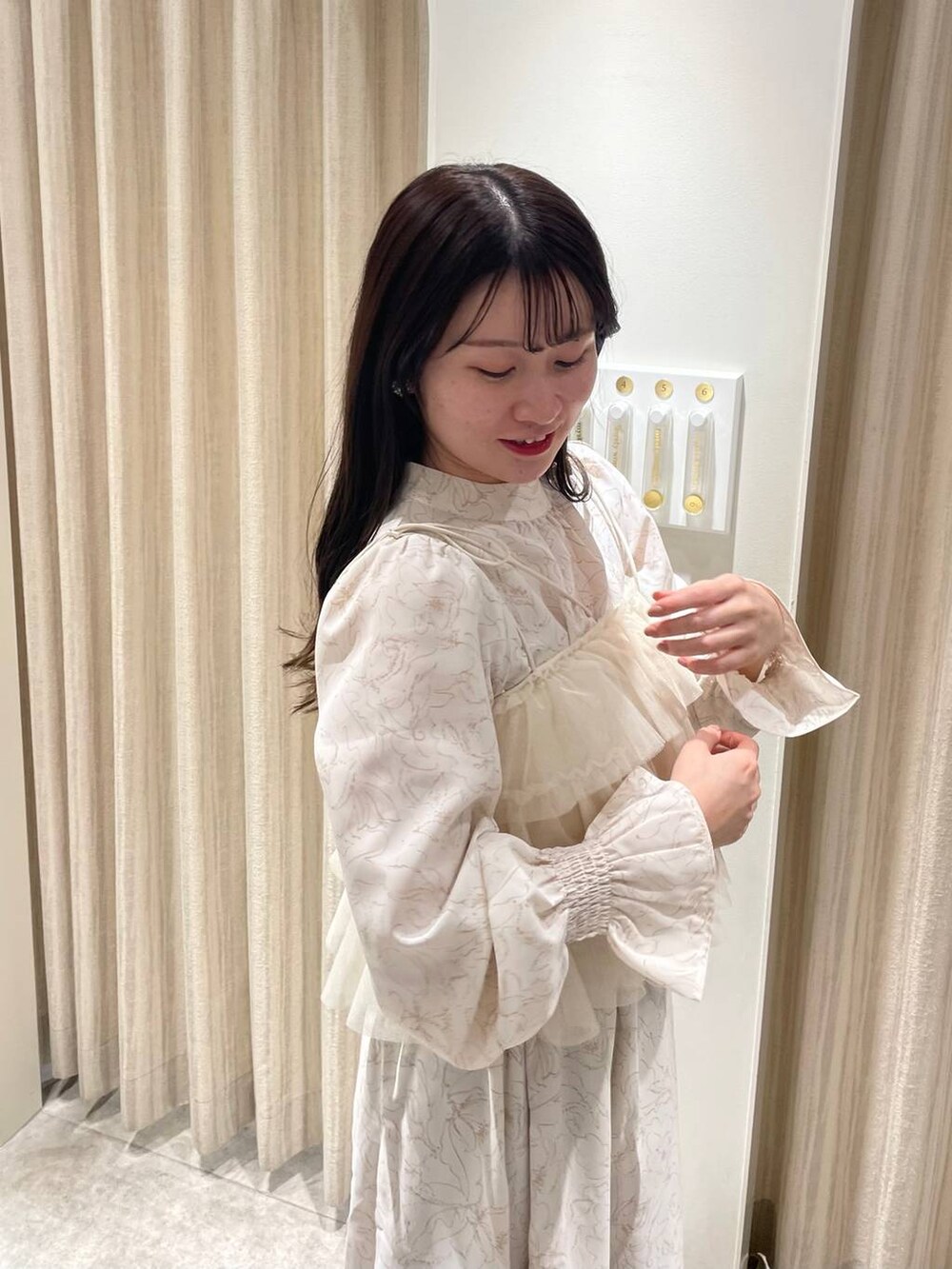 ホワイト系のブーツ、ベージュ系のワンピース、ホワイト系のブルゾンを着用したレディースの冬コーディネートの8枚目の写真