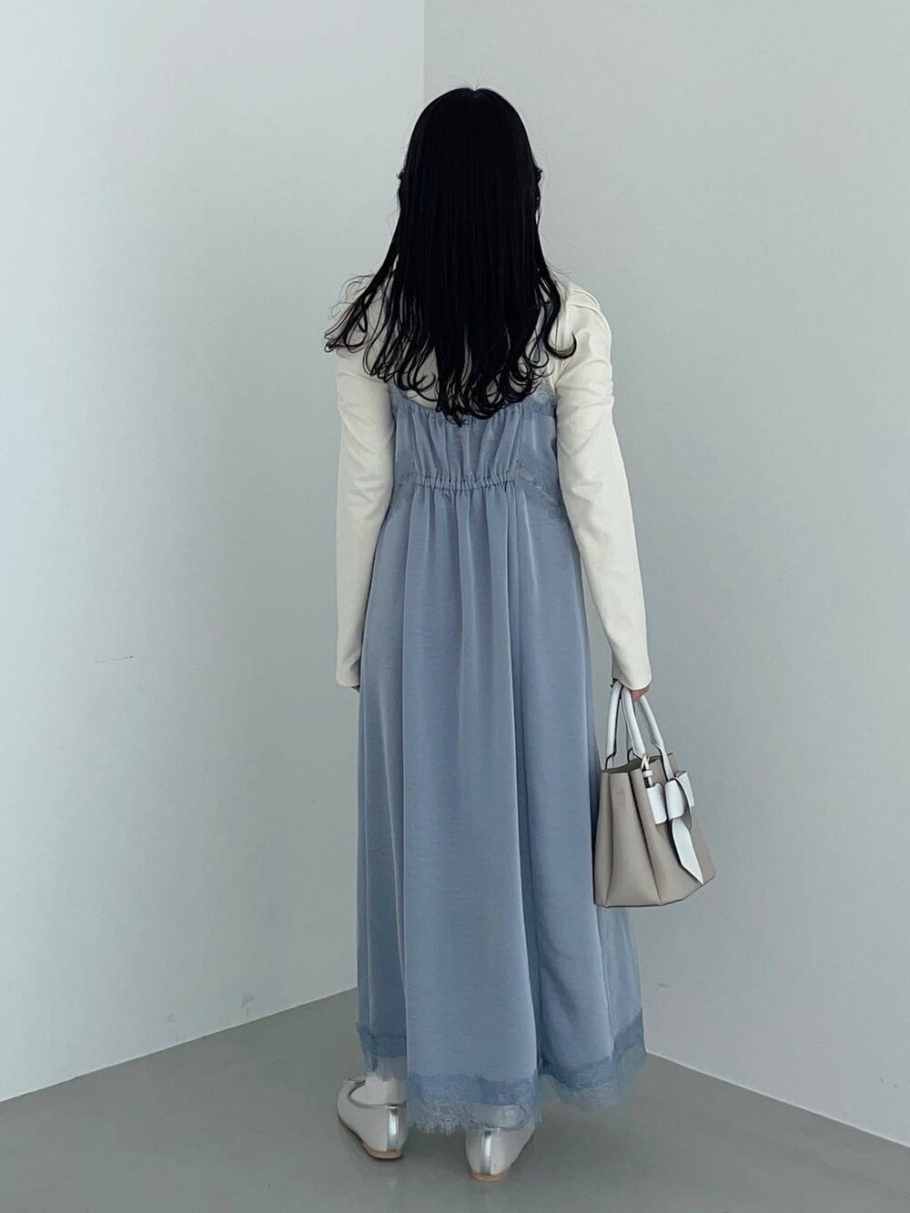 ベージュ系のショルダーバッグ、ホワイト系のマウンテンパーカー、シルバー系のバレエシューズを着用したレディースの春コーディネートの6枚目の写真