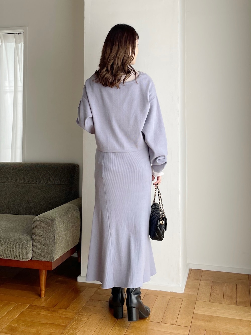 ブルー系のワンピース、ホワイト系のTシャツ/カットソー、ブラック系のショルダーバッグを着用したレディースの冬コーディネートの2枚目の写真