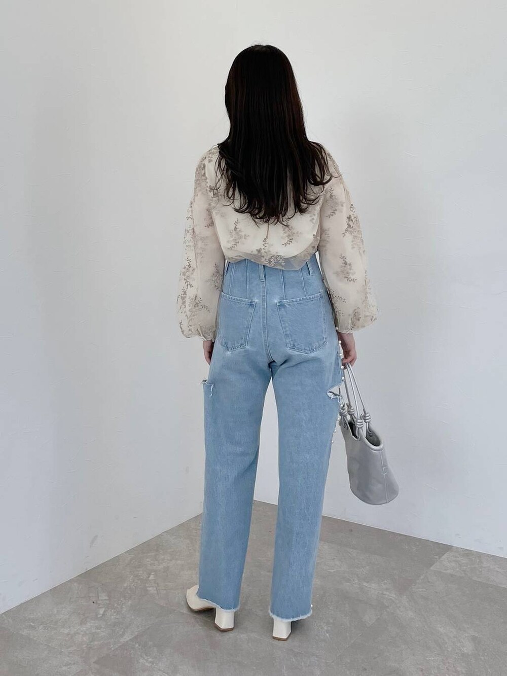 ホワイト系のシャツ/ブラウス、シルバー系のハンドバッグ、ホワイト系のブーツを着用したレディースの冬コーディネートの5枚目の写真