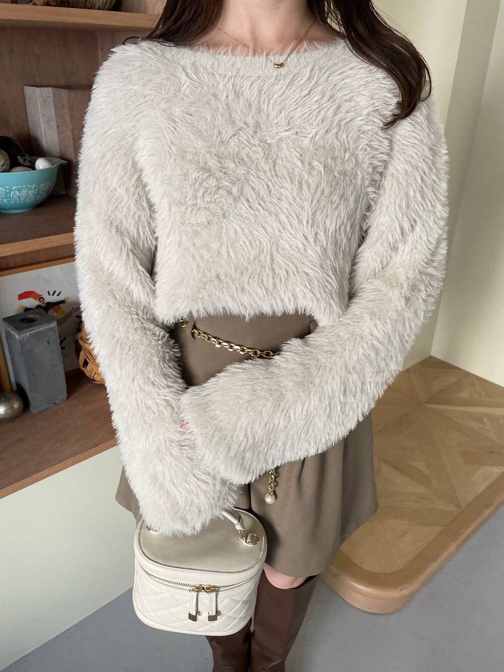 ブラウン系のその他パンツ、ブラウン系のブーツ、ホワイト系のショルダーバッグを着用したレディースの冬コーディネートの4枚目の写真