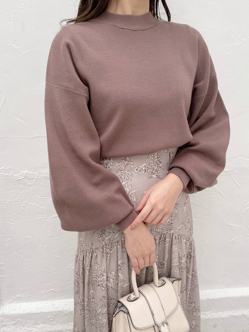 ホワイト系のハンドバッグ、ブラウン系のニット/セーター、ブラウン系のブーツを着用したレディースの冬コーディネートの3枚目の写真