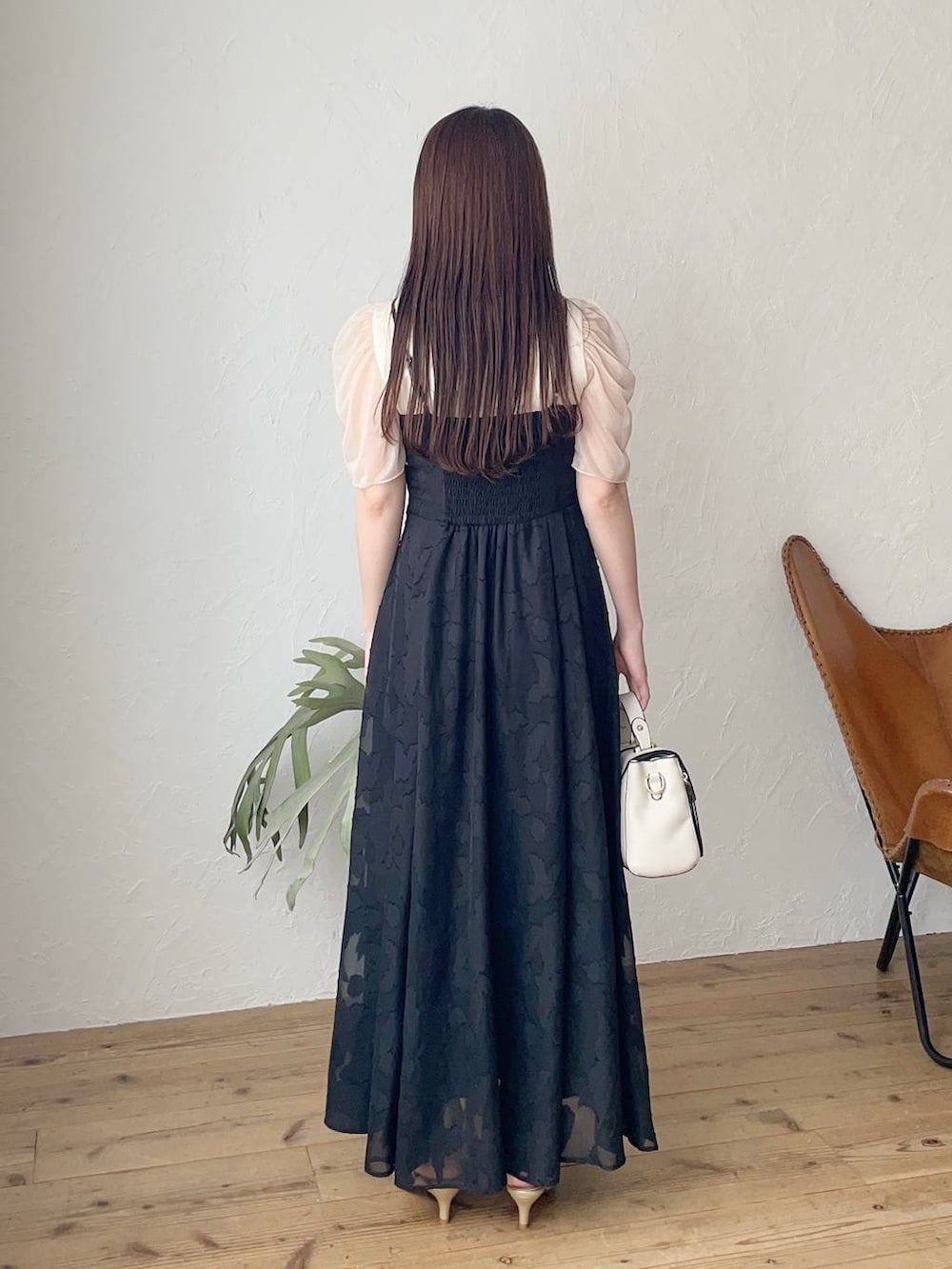 ブラック系のワンピース、ホワイト系のTシャツ/カットソー、ゴールド系のパンプスを着用したレディースの春コーディネートの2枚目の写真