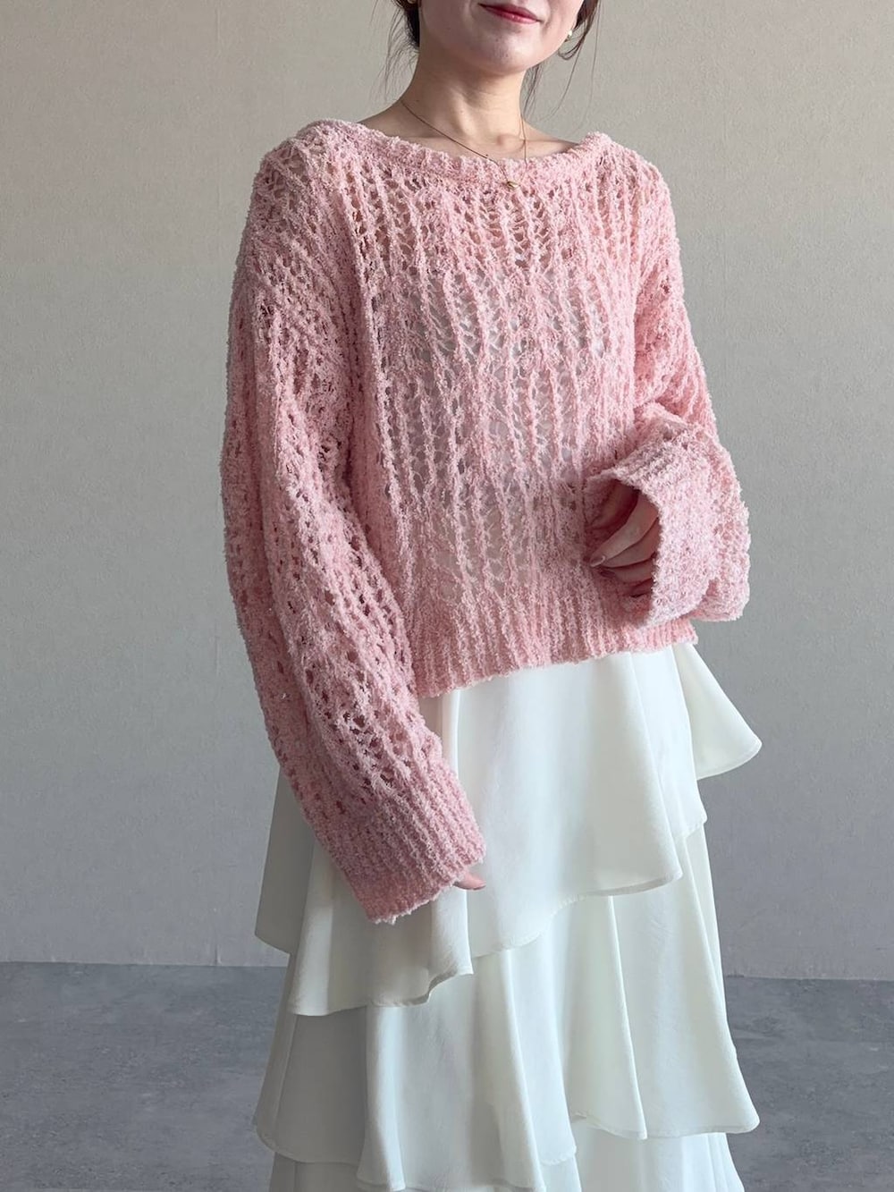 ブラック系のハンドバッグ、ブルー系のニット/セーター、ホワイト系のスカートを着用したレディースの冬コーディネートの3枚目の写真