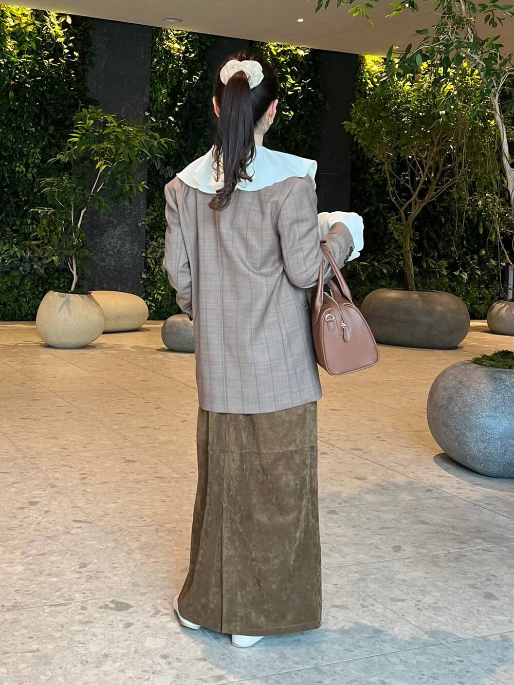 ブラウン系のショルダーバッグ、ホワイト系のシャツ/ブラウス、ベージュ系のテーラードジャケットを着用したレディースの秋コーディネートの2枚目の写真