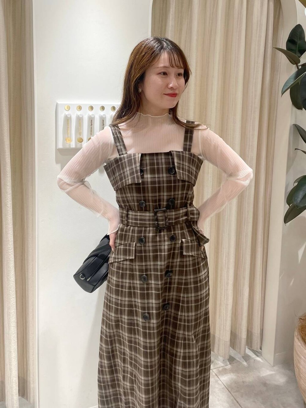 ブラック系のボストンバッグ、ブラック系のブーツ、ホワイト系のブルゾンを着用したレディースの秋コーディネートの3枚目の写真