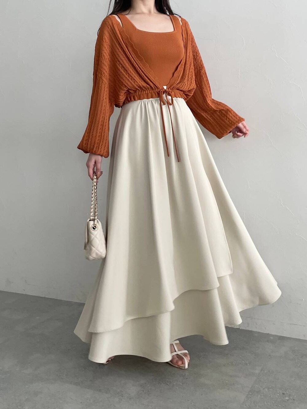 ホワイト系のショルダーバッグ、オレンジ系のカーディガン/ボレロ、ホワイト系のスカートを着用したレディースの夏コーディネートの4枚目の写真