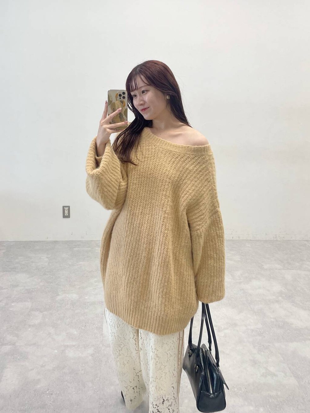 ブラック系のブーツ、ホワイト系のその他パンツ、ブラック系のハンドバッグを着用したレディースの秋コーディネートの4枚目の写真