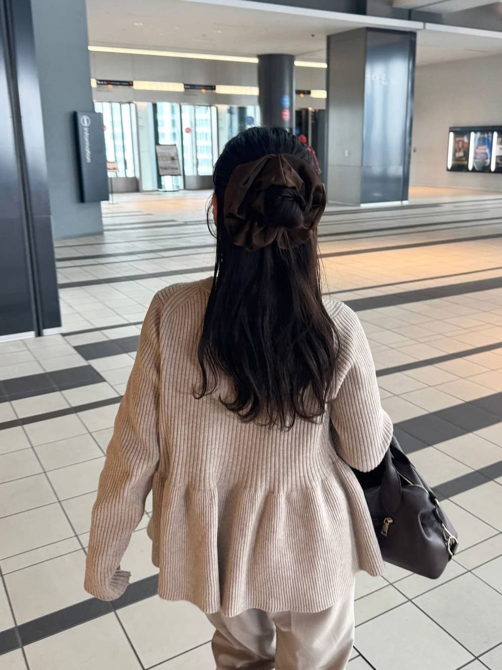 ブラウン系のボストンバッグ、ベージュ系のその他パンツ、ブラウン系のシュシュを着用したレディースの春コーディネートの3枚目の写真