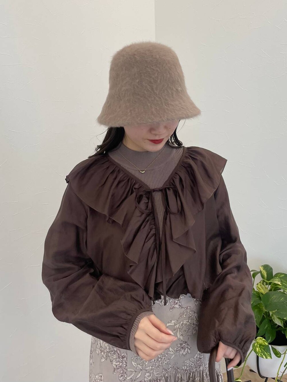 ブラウン系のハンドバッグ、ホワイト系のブーツ、ブラウン系のシャツ/ブラウスを着用したレディースの冬コーディネートの4枚目の写真