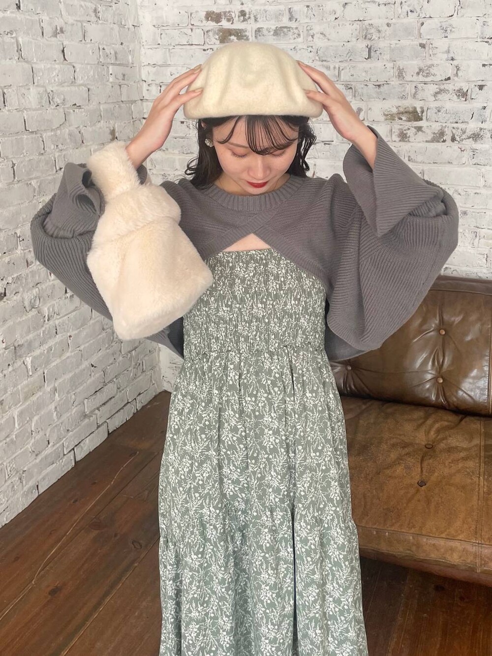 ホワイト系のブーツ、ホワイト系のハンドバッグ、グリーン系のワンピースを着用したレディースの冬コーディネートの4枚目の写真