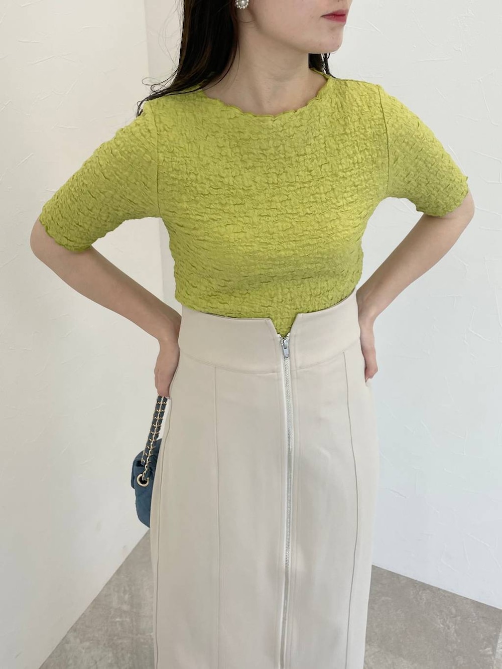 シルバー系のバレエシューズ、ベージュ系のスカート、ブルー系のショルダーバッグを着用したレディースの春コーディネートの3枚目の写真