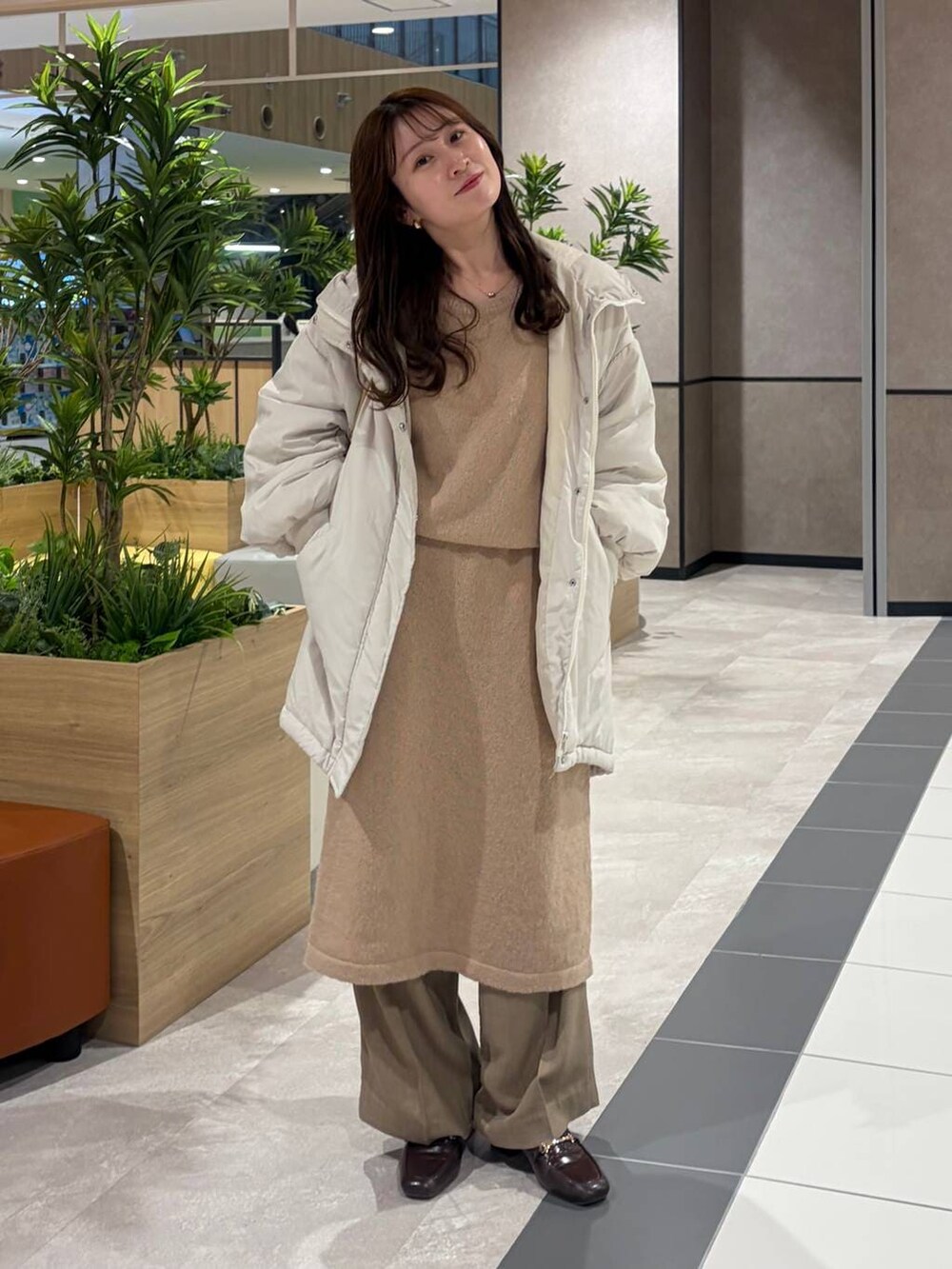 ゴールド系のボストンバッグ、ピンク系のワンピースを着用したレディースの冬コーディネートの3枚目の写真