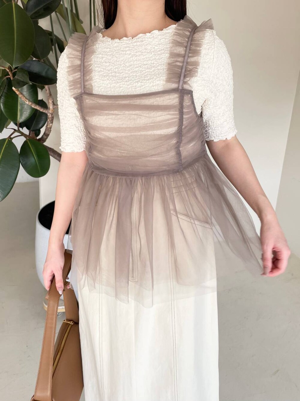 ホワイト系のスカート、ベージュ系のキャミソール、ホワイト系のTシャツ/カットソーを着用したレディースの春コーディネートの5枚目の写真