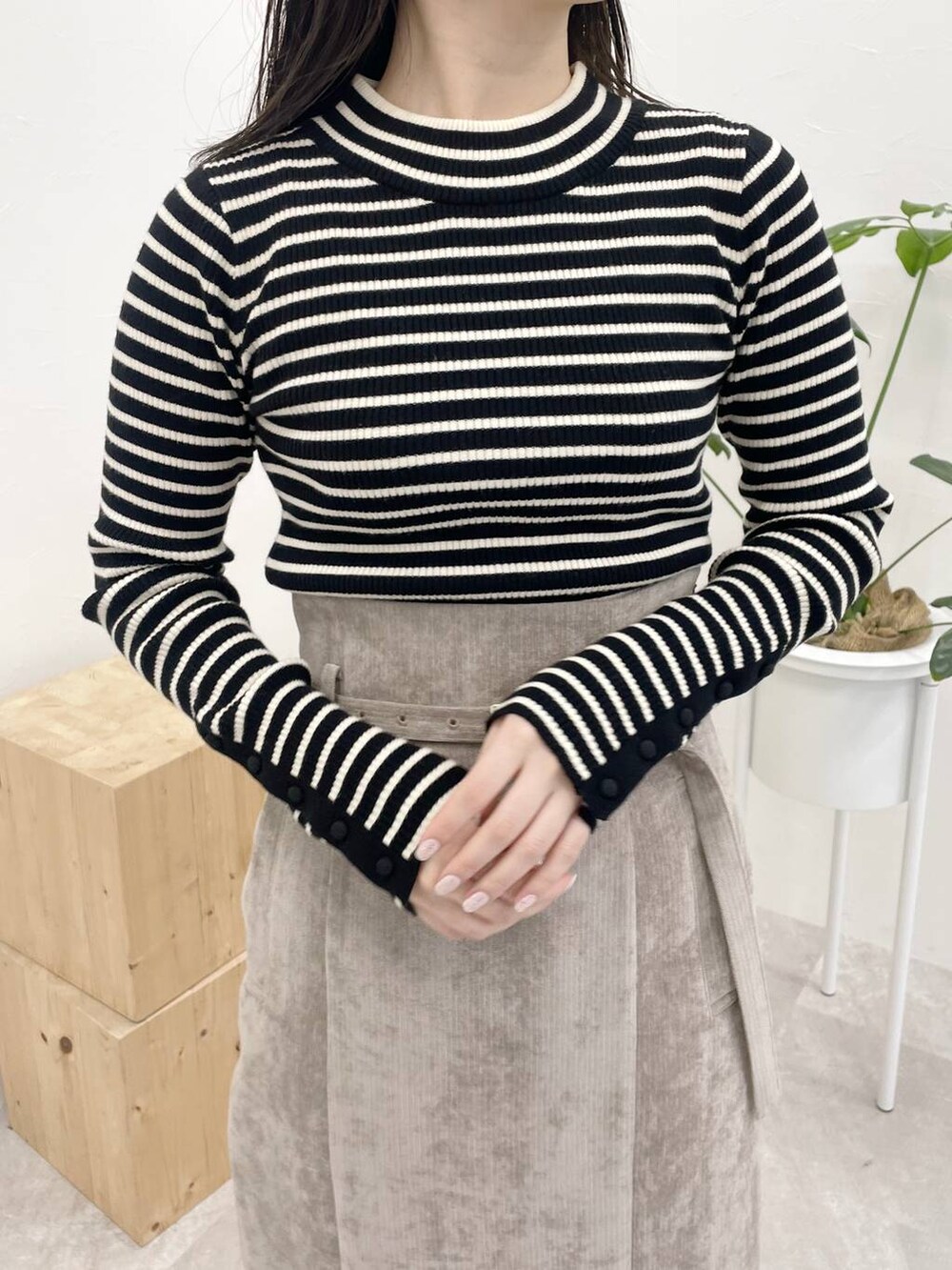 ブラウン系のスカート、グレー系のブーツ、ブラック系のニット/セーターを着用したレディースの冬コーディネートの4枚目の写真