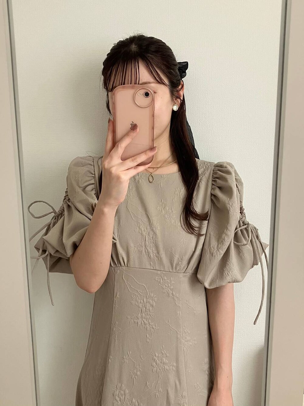 ベージュ系のワンピースを着用したレディースの春コーディネートの2枚目の写真