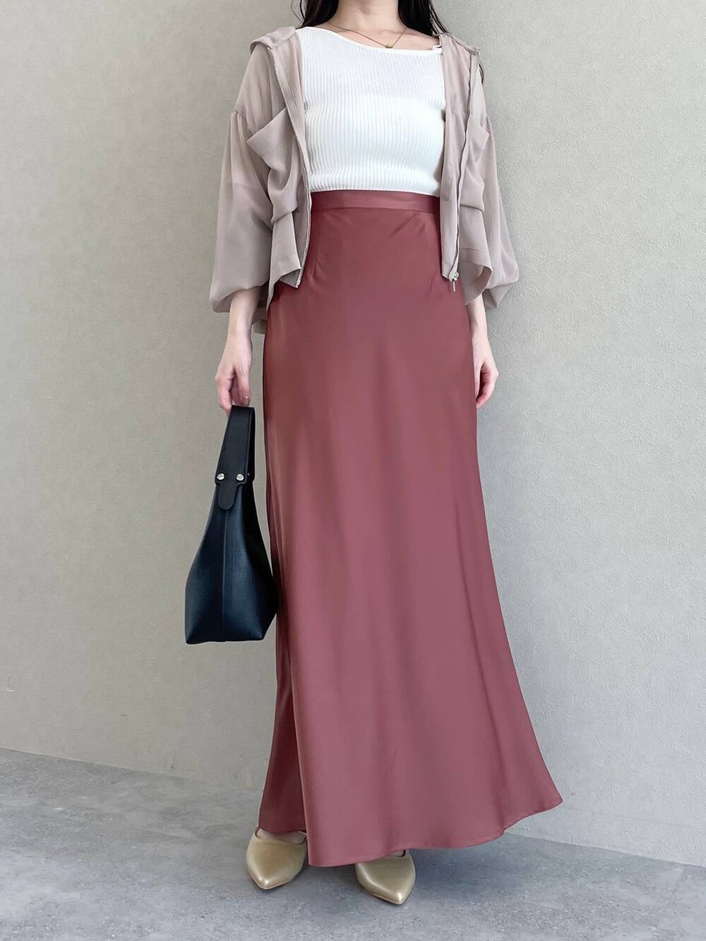 ベージュ系のパーカー、ブラック系のショルダーバッグ、ブラウン系のスカートを着用したレディースの春コーディネートの3枚目の写真