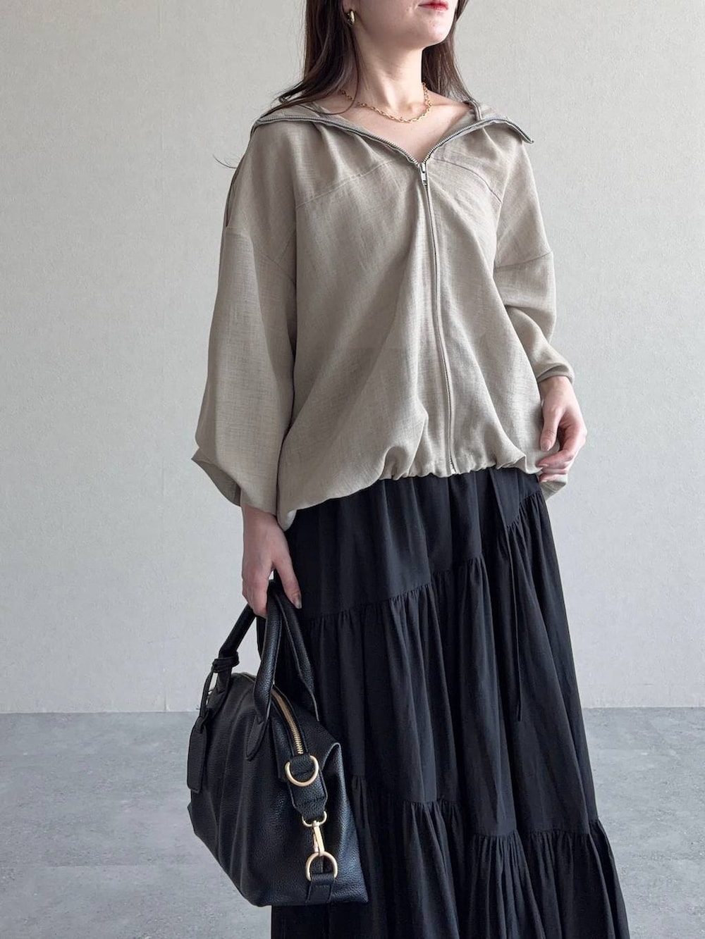 ブラック系のボストンバッグ、ブラウン系のサンダル、ブラック系のスカートを着用したレディースの夏コーディネートの3枚目の写真