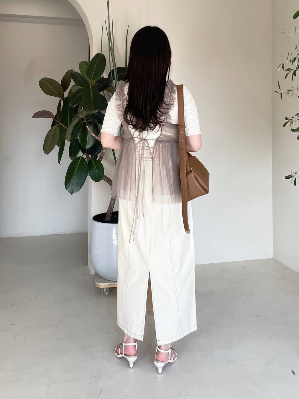 ホワイト系のスカート、ベージュ系のキャミソール、ホワイト系のTシャツ/カットソーを着用したレディースの春コーディネートの2枚目の写真