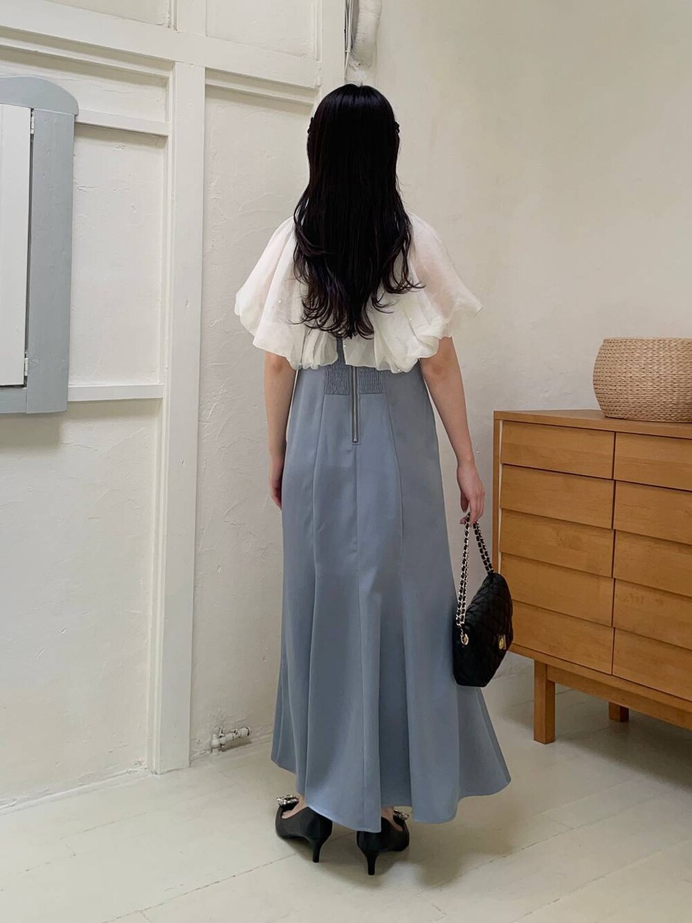 ブラック系のパンプス、ブラック系のショルダーバッグ、ブルー系のドレスを着用したレディースの春コーディネートの2枚目の写真
