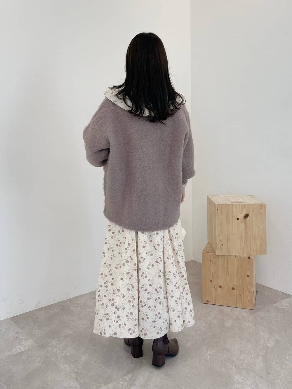 ブラウン系のカーディガン/ボレロ、ホワイト系のハンドバッグ、ブラウン系のブーツを着用したレディースの秋コーディネートの2枚目の写真