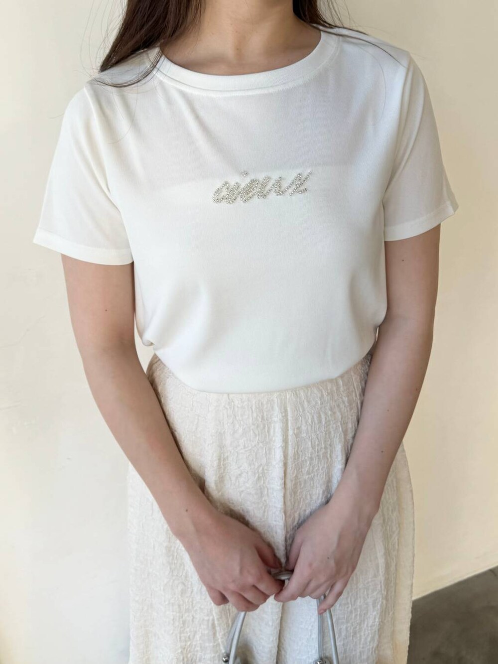 シルバー系のバレエシューズ、ホワイト系のスカート、ホワイト系のTシャツ/カットソーを着用したレディースの春コーディネートの3枚目の写真
