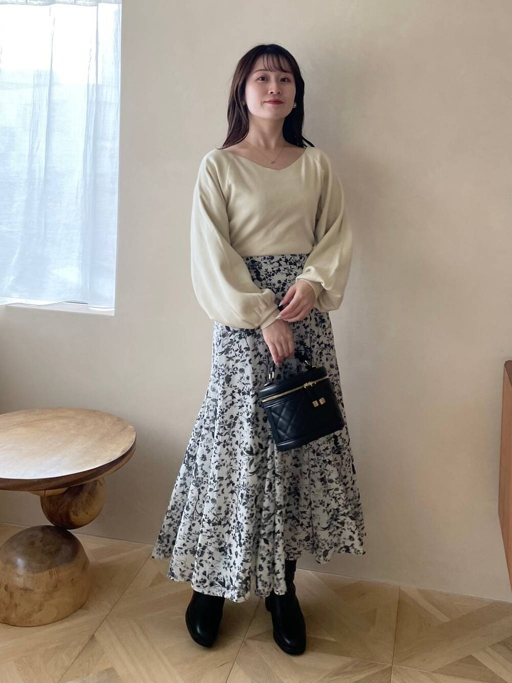 ブラック系のブーツ、ブラック系のショルダーバッグ、ホワイト系のワンピースを着用したレディースの冬コーディネートの4枚目の写真