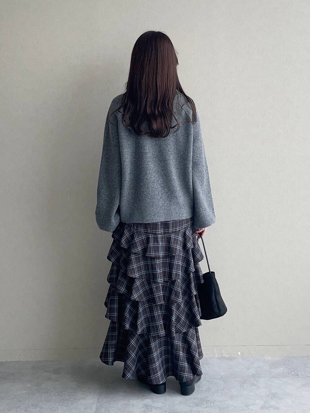 グレー系のニット/セーター、ブラウン系のスカート、ブラック系のローファーを着用したレディースの秋コーディネートの4枚目の写真