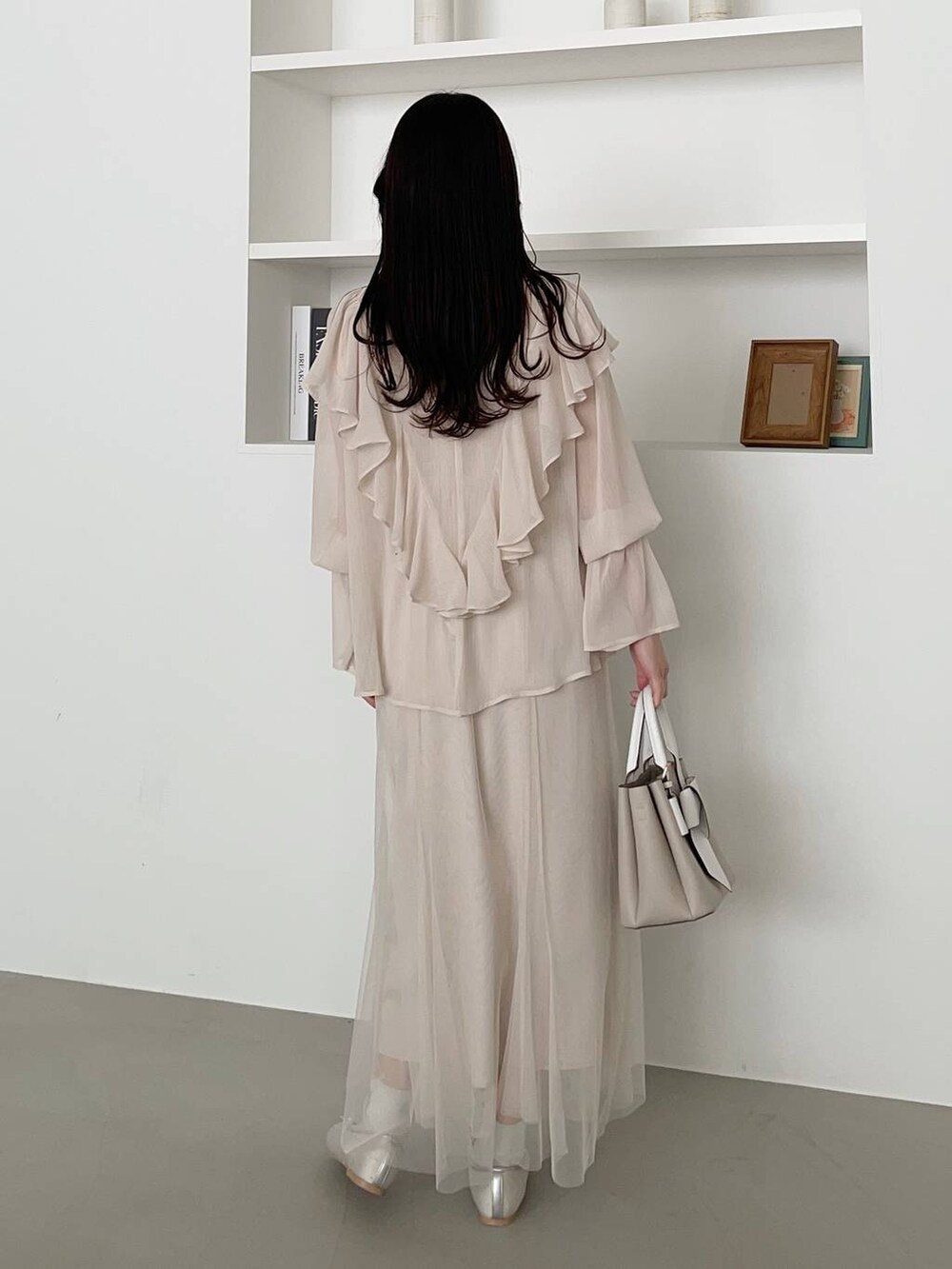 ベージュ系のショルダーバッグ、シルバー系のバレエシューズ、ホワイト系のワンピースを着用したレディースの春コーディネートの2枚目の写真