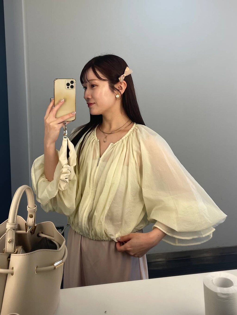 ベージュ系のパンプス、ホワイト系のシャツ/ブラウス、ベージュ系のスカートを着用したレディースの夏コーディネートの2枚目の写真