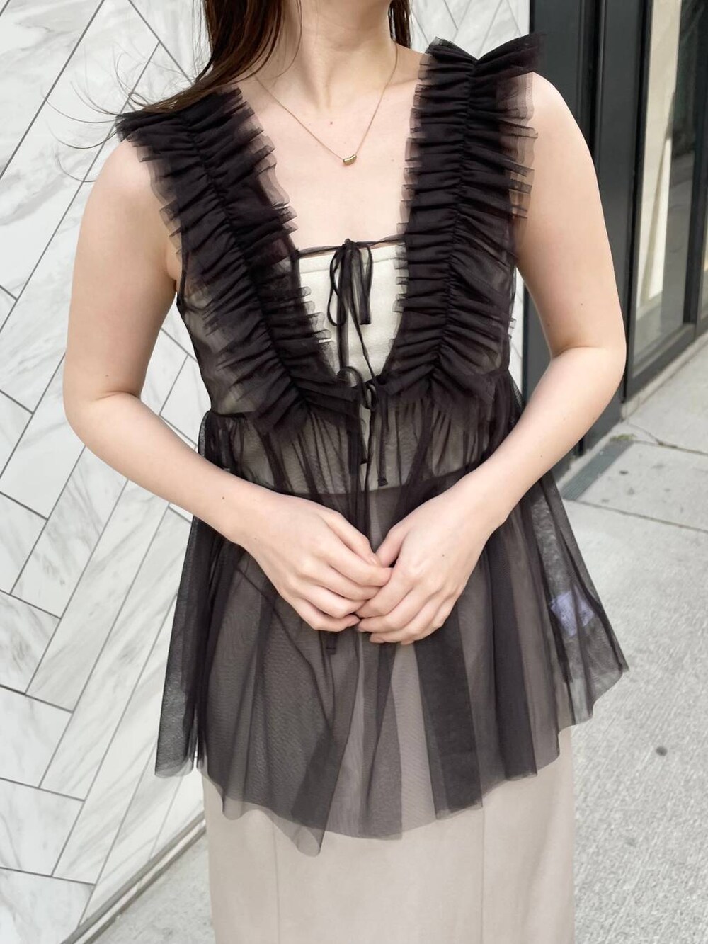 ホワイト系のキャミソール、ベージュ系のサンダル、ブラウン系のショルダーバッグを着用したレディースの夏コーディネートの3枚目の写真