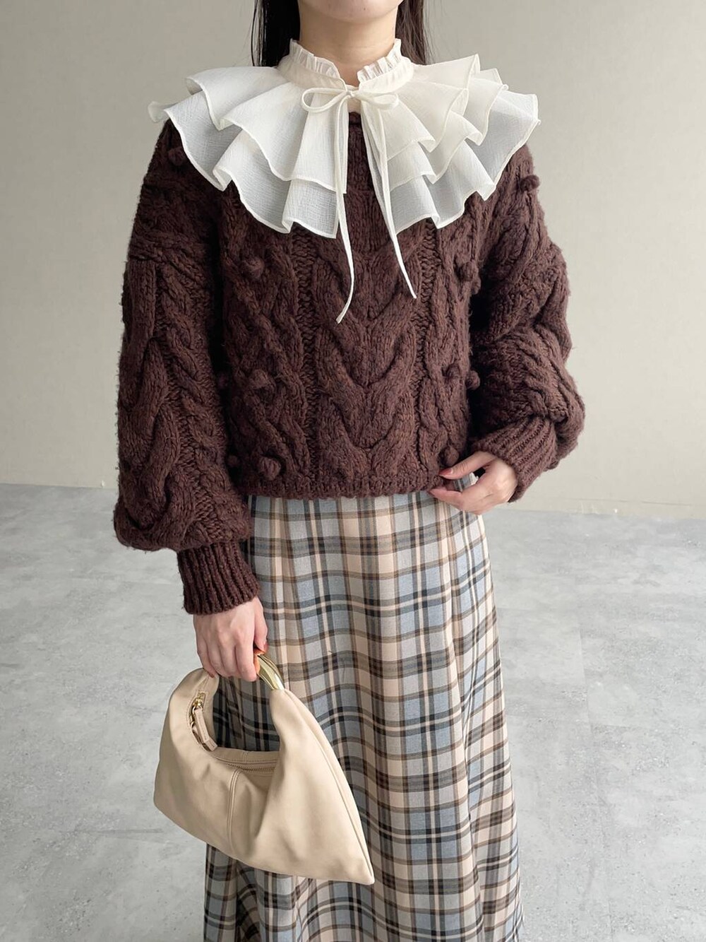 ベージュ系のハンドバッグ、ベージュ系のワンピースを着用したレディースの秋コーディネートの4枚目の写真