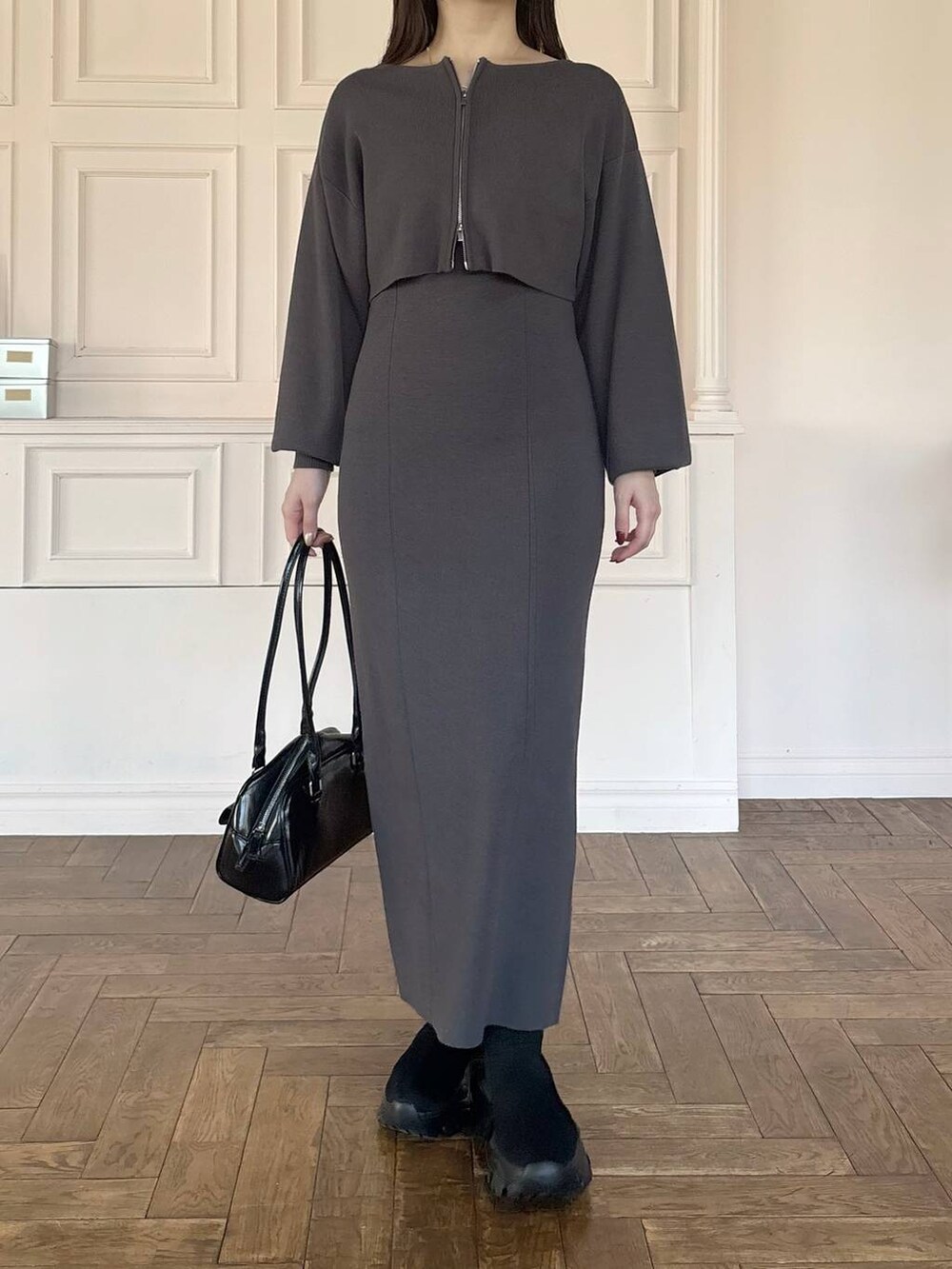 ブラック系のブーツ、グレー系のワンピース、ブラック系のハンドバッグを着用したレディースの冬コーディネートの4枚目の写真