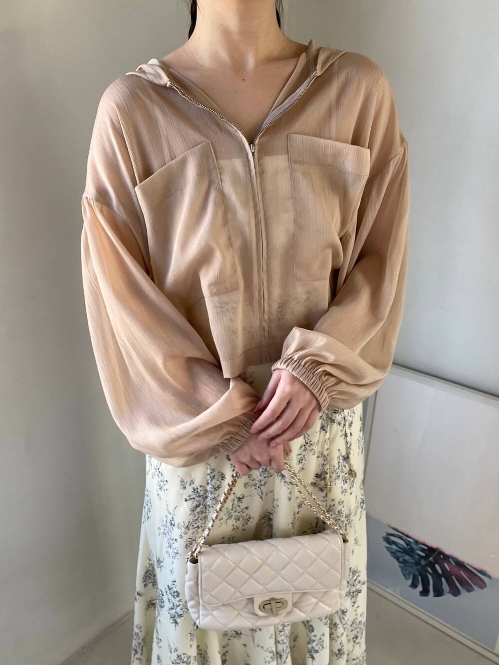 シルバー系のバレエシューズ、ホワイト系のショルダーバッグ、ベージュ系のパーカーを着用したレディースの春コーディネートの3枚目の写真