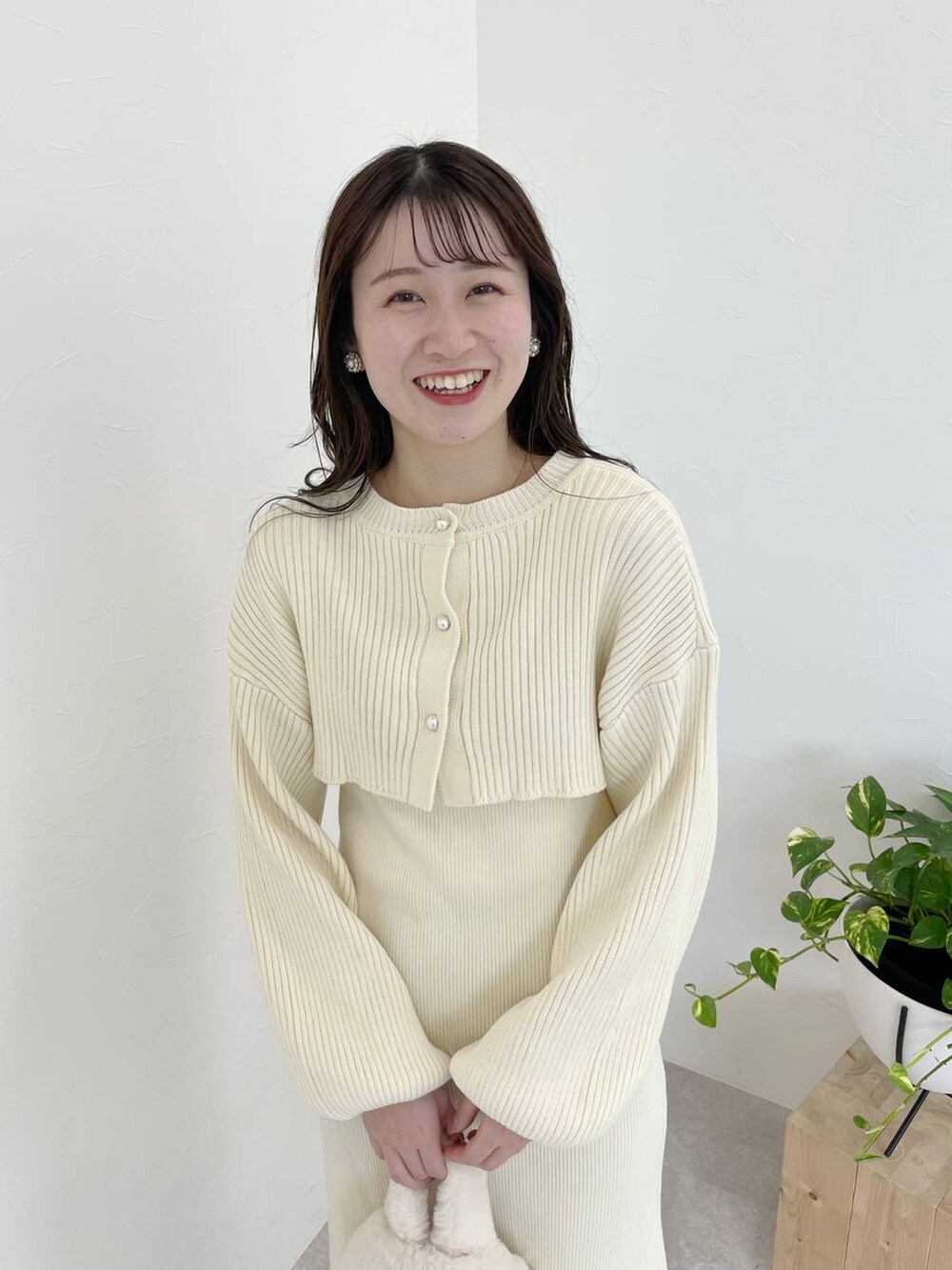 ホワイト系のブーツ、ホワイト系のハンドバッグ、ブラウン系のチェスターコートを着用したレディースの秋コーディネートの7枚目の写真