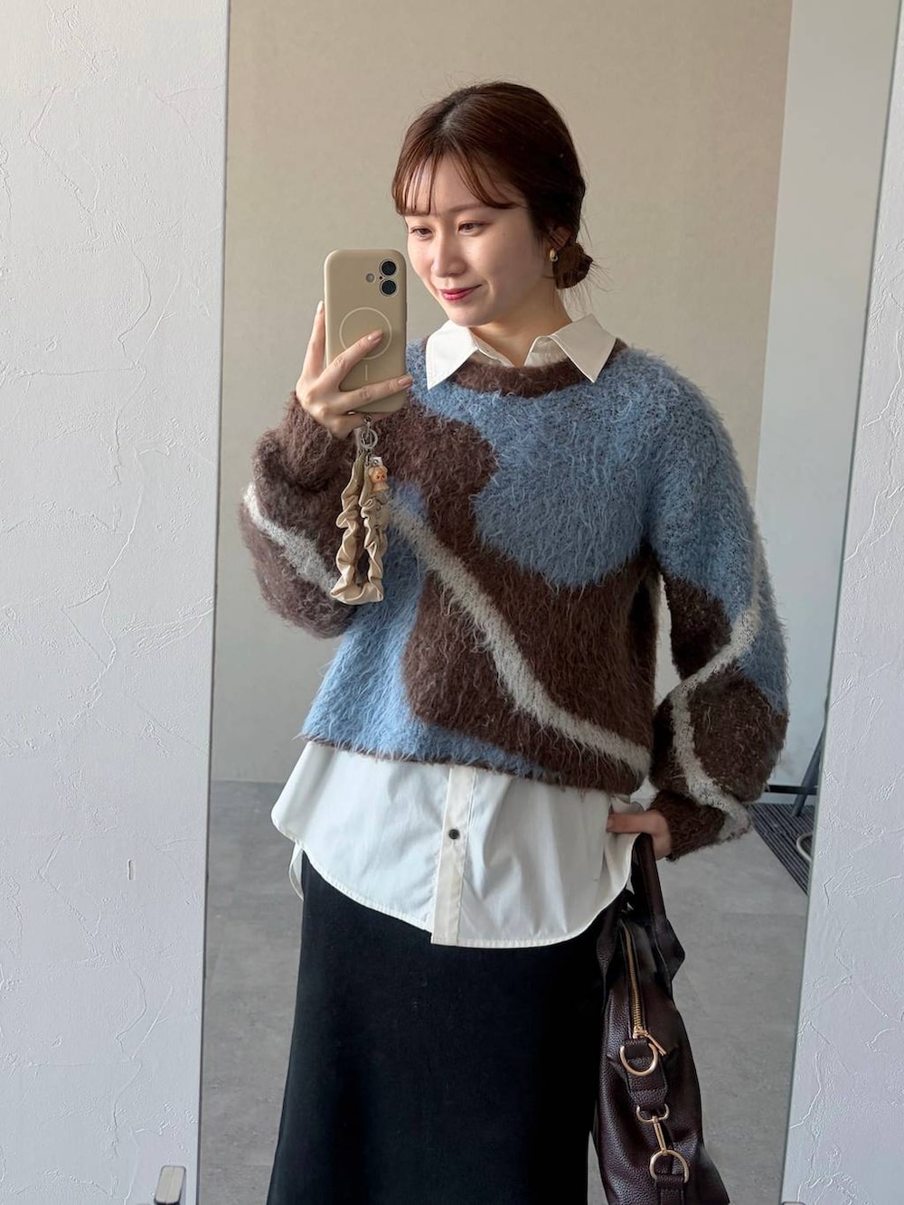 ブラウン系のニット/セーター、ブラウン系のボストンバッグ、ブラック系のスカートを着用したレディースの冬コーディネートの3枚目の写真