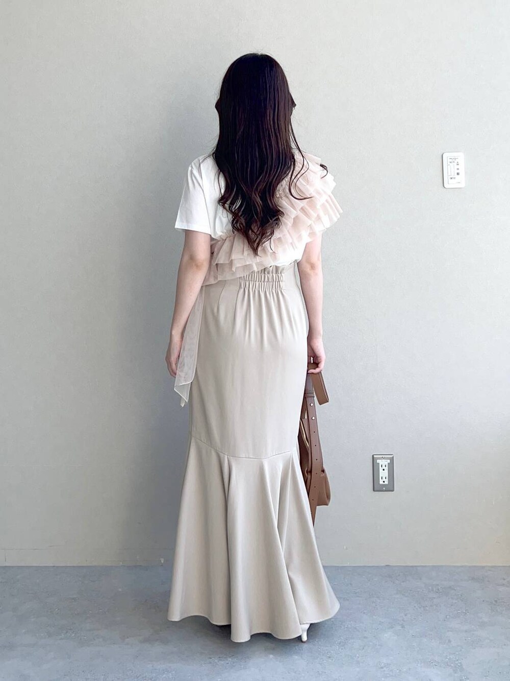 ブラウン系のショルダーバッグ、ホワイト系のサンダル、ホワイト系のTシャツ/カットソーを着用したレディースの夏コーディネートの2枚目の写真