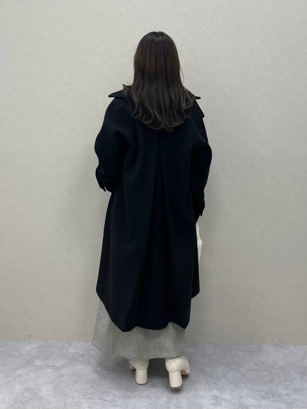 レッド系のニット/セーター、ブラック系のチェスターコート、ホワイト系のブーツを着用したレディースの秋コーディネートの2枚目の写真