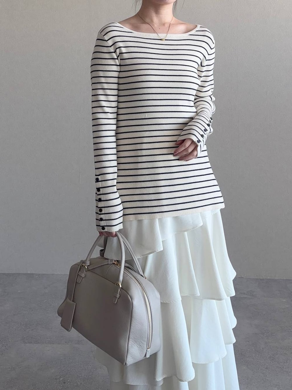 ベージュ系のハンドバッグ、ホワイト系のサンダル、ブルー系のトレンチコートを着用したレディースの冬コーディネートの5枚目の写真