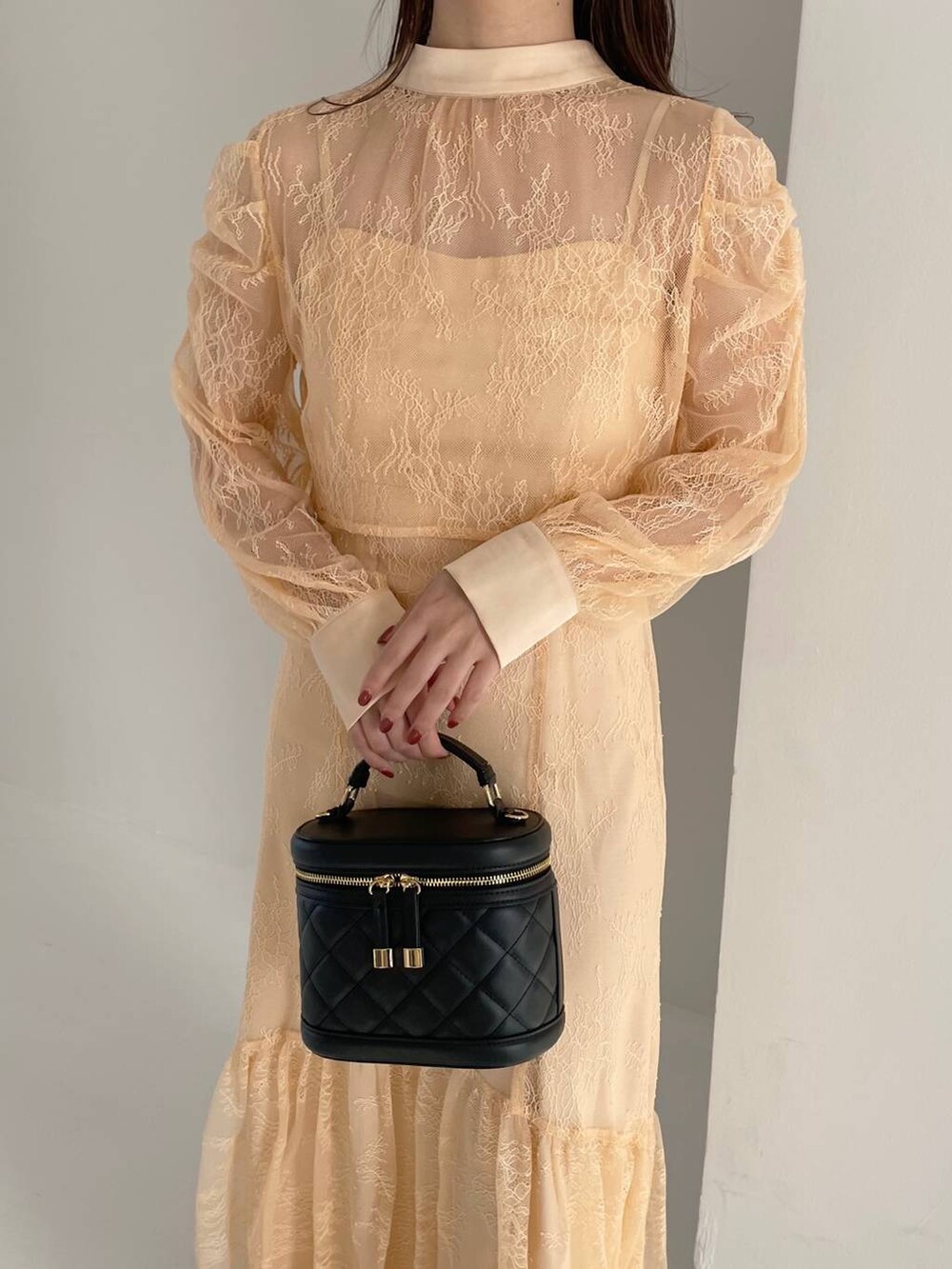 ブラック系のブーツ、ブラック系のショルダーバッグ、オレンジ系のドレスを着用したレディースの秋コーディネートの4枚目の写真