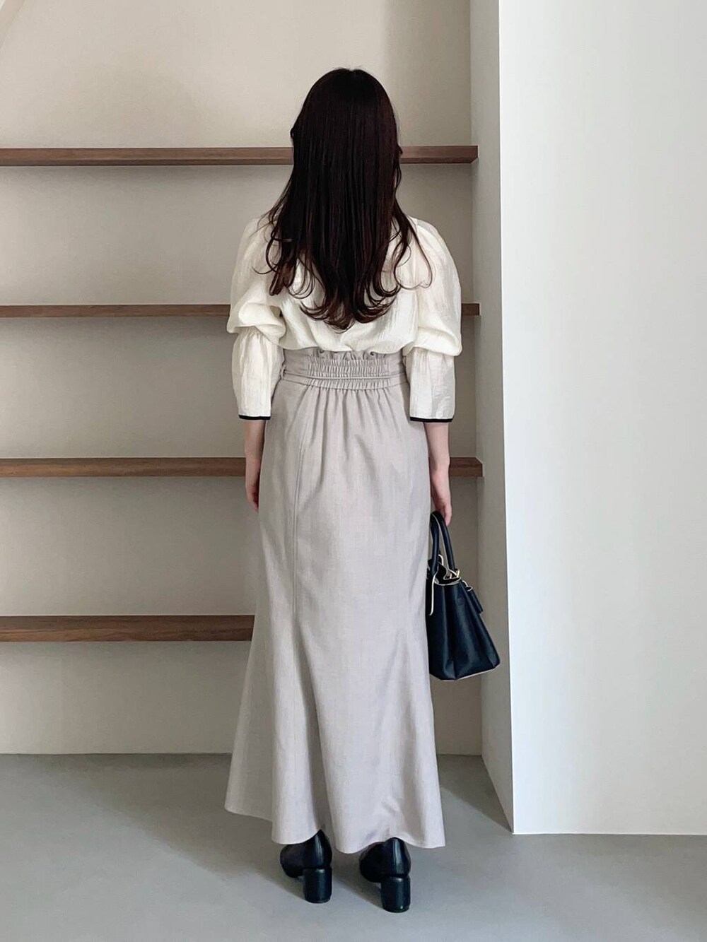 ブラック系のショルダーバッグ、ホワイト系のシャツ/ブラウス、ブラック系のパンプスを着用したレディースの冬コーディネートの4枚目の写真