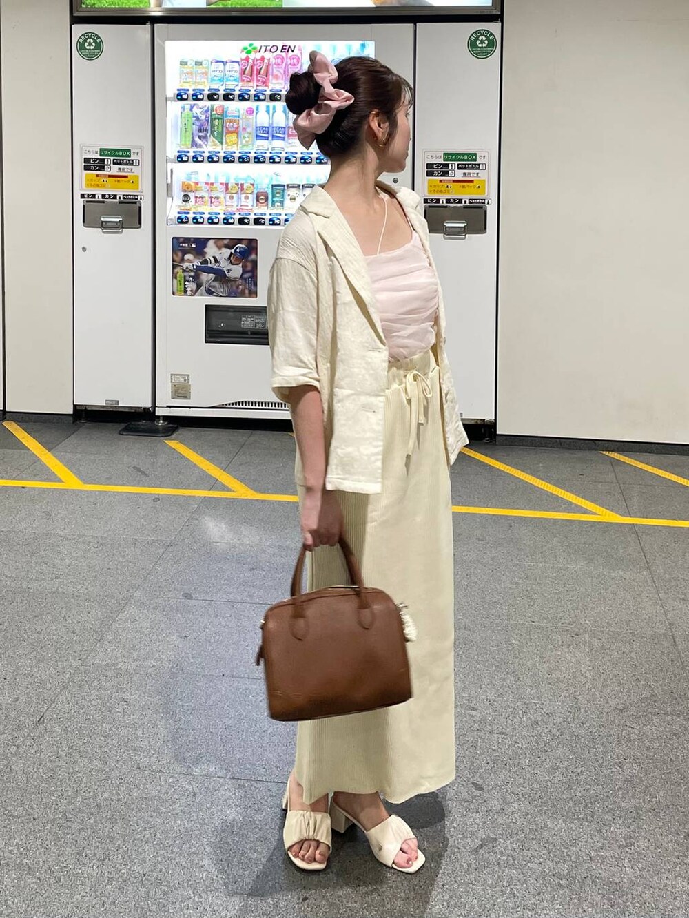 ホワイト系のスカート、ホワイト系のテーラードジャケット、ブラウン系のショルダーバッグを着用したレディースの夏コーディネートの3枚目の写真