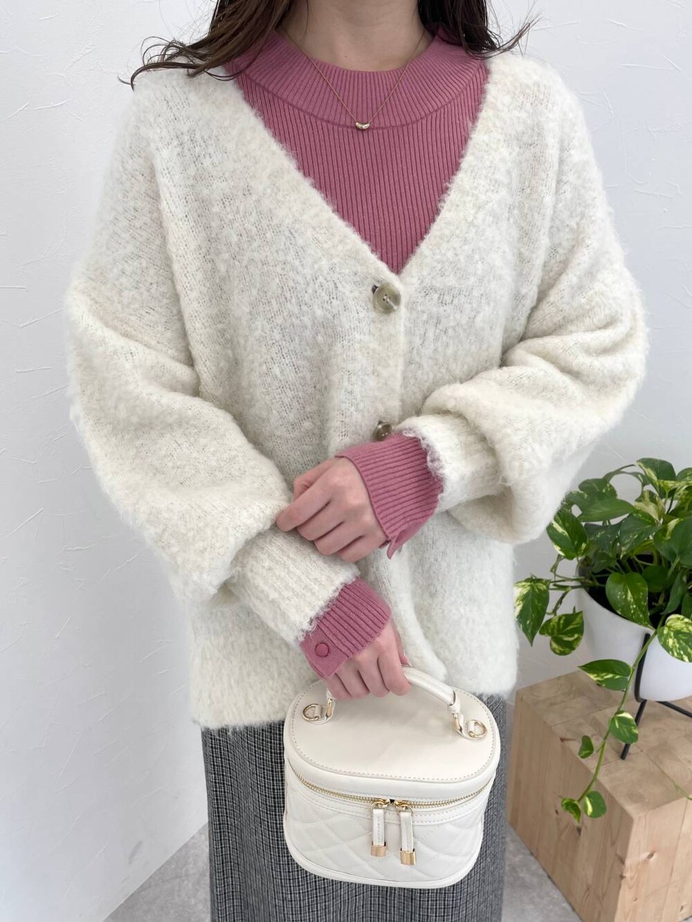 ホワイト系のブーツ、ピンク系のニット/セーター、ホワイト系のカーディガン/ボレロを着用したレディースの冬コーディネートの3枚目の写真