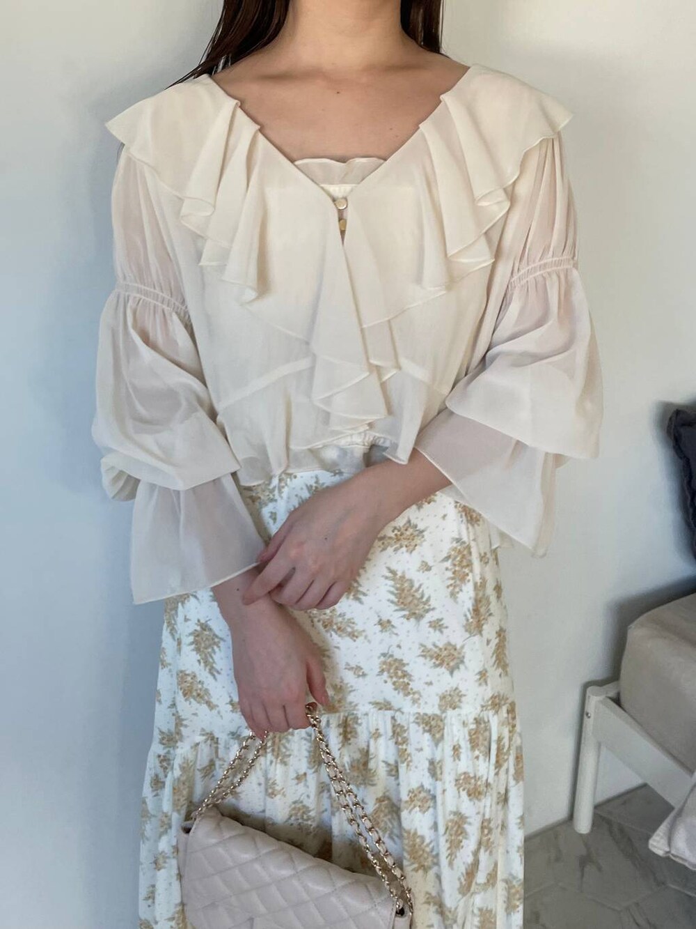 イエロー系のスカート、ホワイト系のシャツ/ブラウス、ホワイト系のショルダーバッグを着用したレディースの冬コーディネートの3枚目の写真